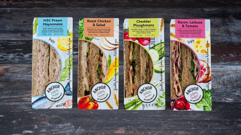 New Sandwich packaging depicts illustrations of food on 4 sandwich packs lined up on an old wooden bench top.