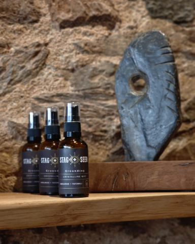 New Packaging design displayed on a wood shelf against brick background in the stag + seer shop.