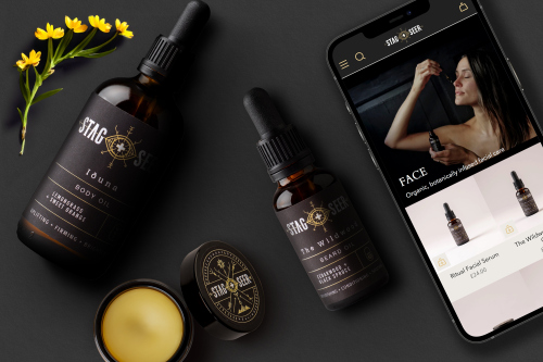 Two bottles of face oil, a jar of balm and an iPhone laying on black card. displayed to showcase new packaging design and website design for Stag + Seer Start brand.